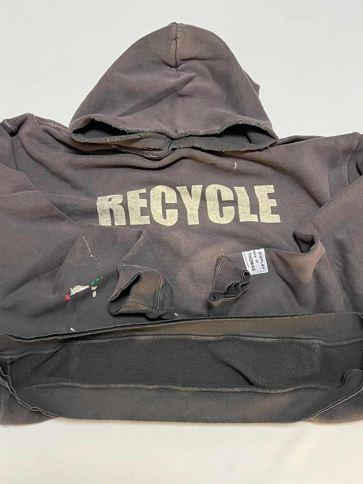 GALLERY DEPT. 90'S RECYCLE HOODIE WASHED BLACK 90'S washed hoodie with distressed eco-friendly slogans. Washed black S-XL. Ready-made garments are washed and dyed again. Multiple spots throughout the body are spray-faded. The ribs are cut and worn.
